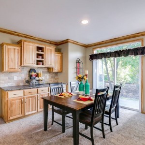 Photo of manufactured home interior dining area with glass doors and wood cabinets